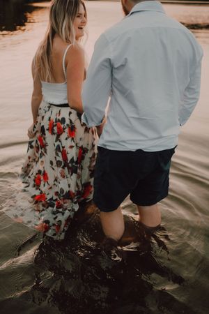 Loving couple hugging while standing ankle deep in water on beach