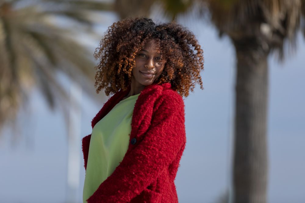 Calm female on sunny day standing on street with palm trees