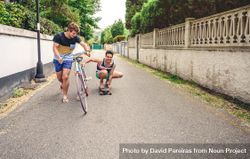 Two men having fun riding bike and skateboard 49mmvv