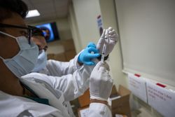 Bethesda, MD, USA - Dec. 14, 2020: Navy Hospitalman  prepare a dose of COVID vaccine 0v81L4