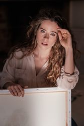 Pensive female artist with canvas