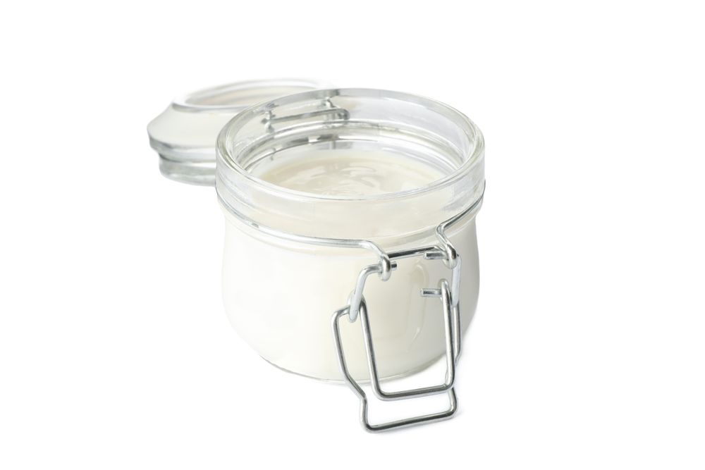 Glass jar with sour cream yogurt isolated on plain background