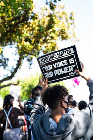 Los Angeles, CA, USA — June 7th, 2020: teen holds BLM sign at rally at a park in East LA