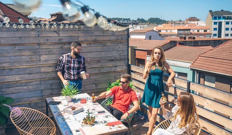 Friends talking and drinking at a party on a terrace
