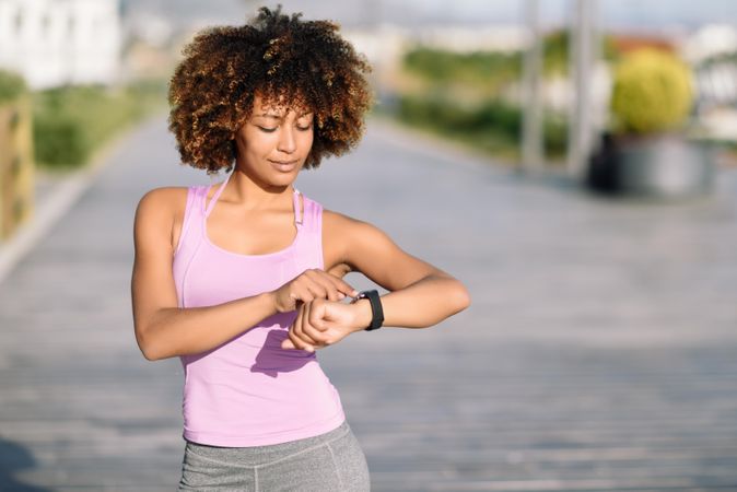 Female with afro hair looking at her smart watch screen