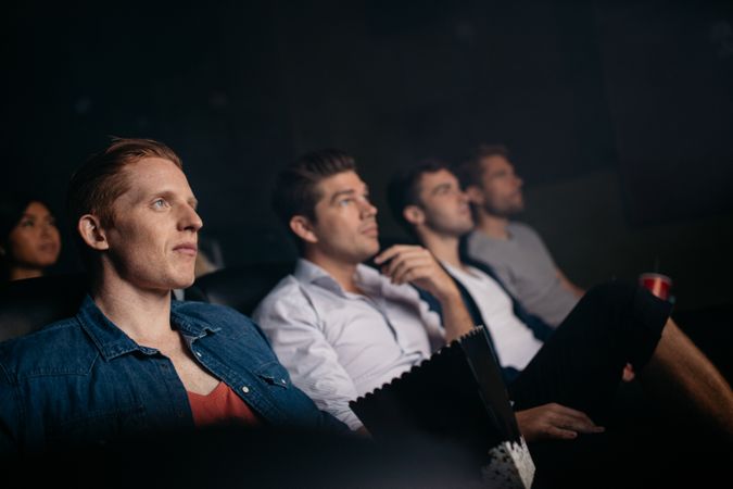 Young friends watching movie in cinema hall
