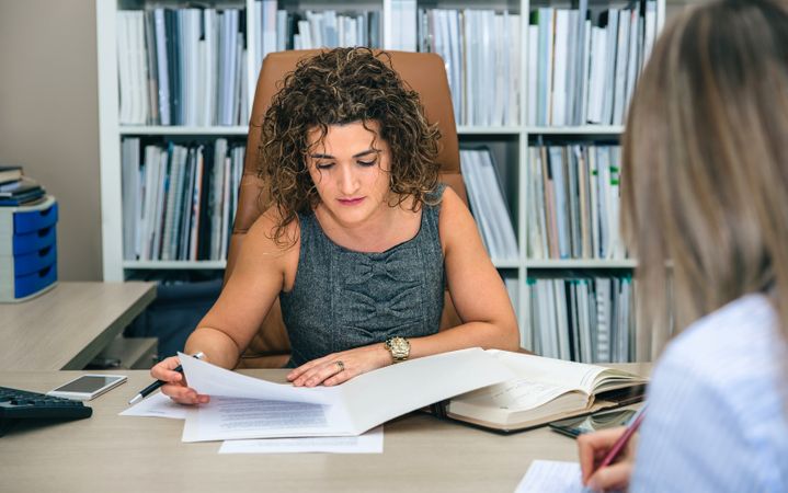 Two businesswoman going through documents in office