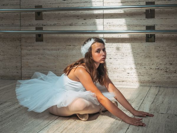 Ballerina stretching while doing ballet in classroom