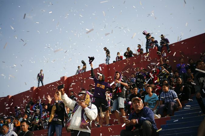 Kedira, East Java Indonesia - October 4, 2019:  Fans in stands at soccer game with confetti
