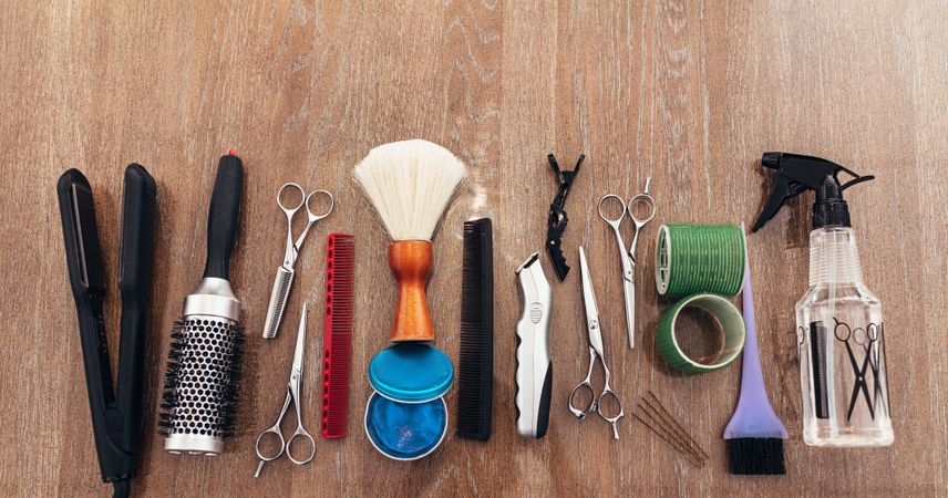 Flat lay of hairdresser’s tools on wooden surface
