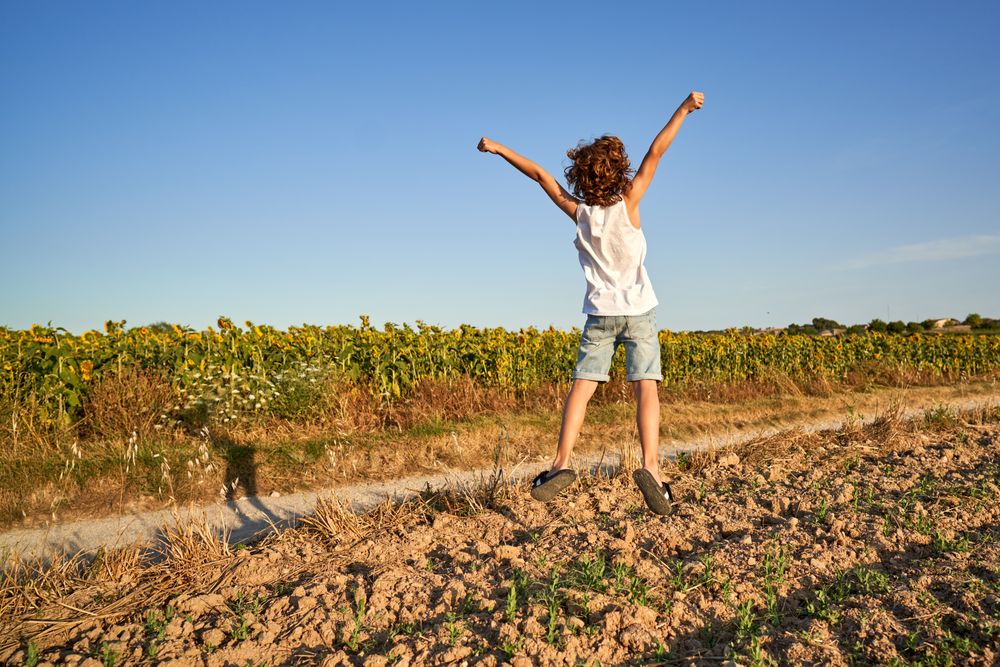 Boy running along road in countryside