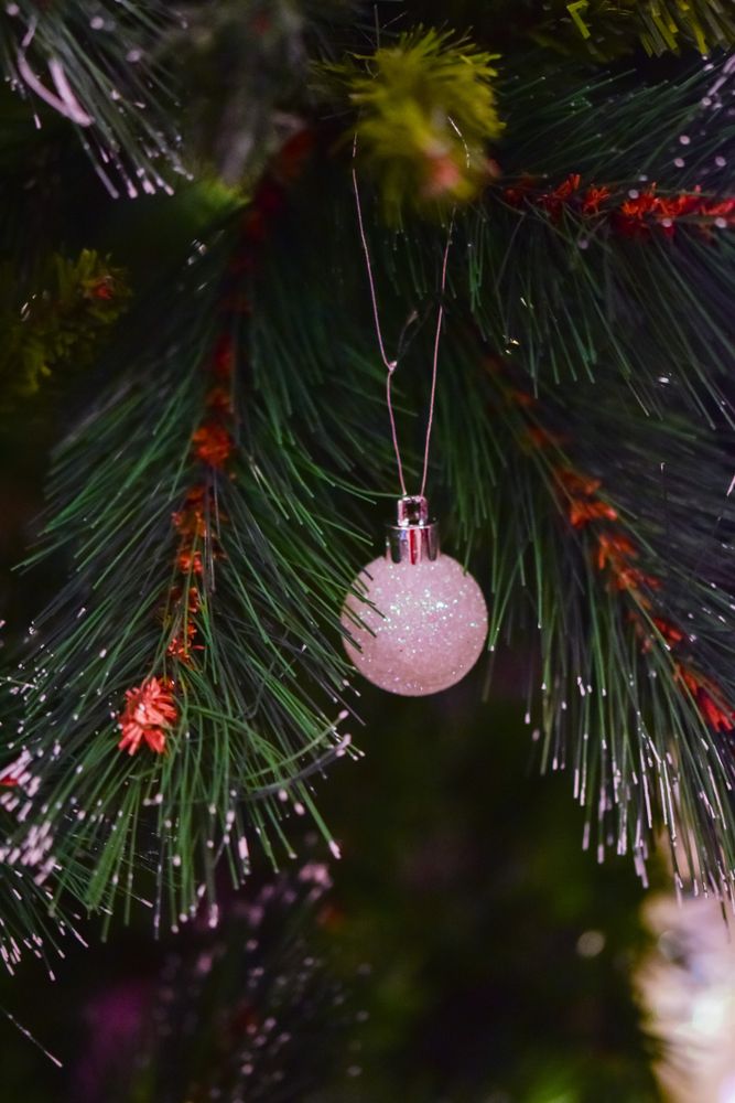 Pink bauble on green Christmas tree