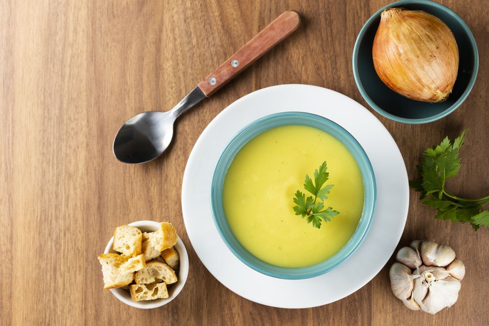 Bowl with onion soup and croutons on the table.