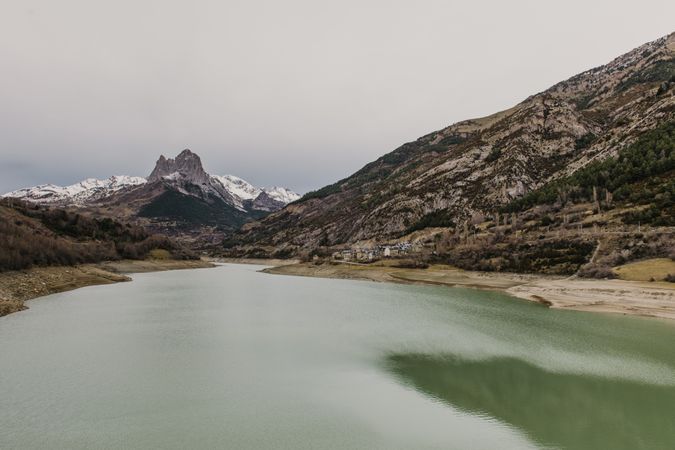 Wonderful lake between hills in snow and cloudy sky