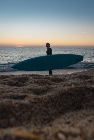 Man practicing paddle surfing with neoprene in a sunrise