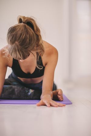 Woman doing leg stretches on yoga mat