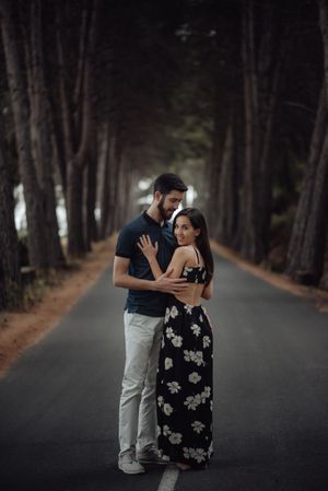 Loving couple embracing on pathway in misty forest