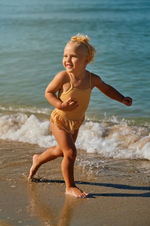 Happy girl running along seashore