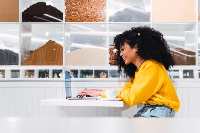 Black woman working on laptop in cafe