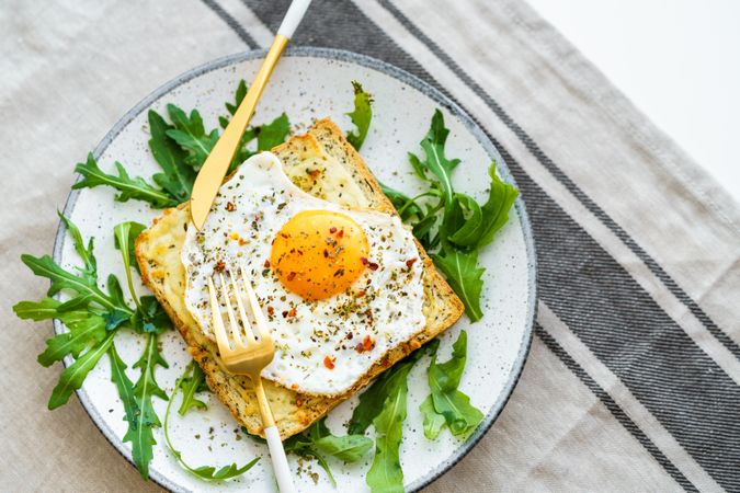 Delicious breakfast of fried eggs with toast and salad.