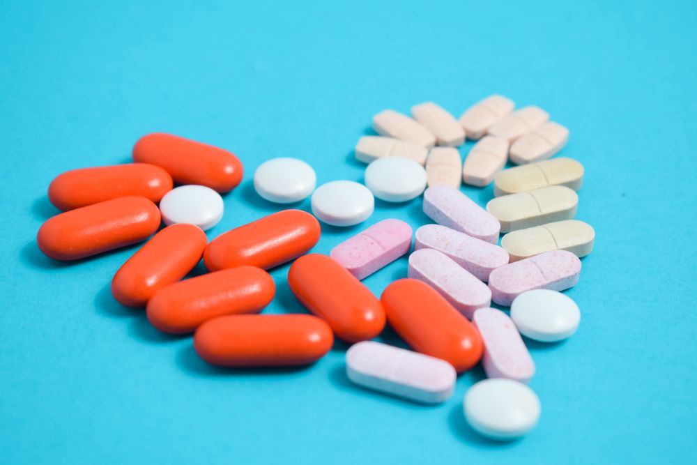 PIlls in heart shape on blue background