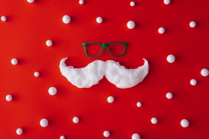 Mustache and glasses on red background with snowballs