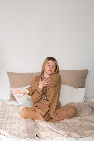 Woman stretching in pajamas with smartwatch
