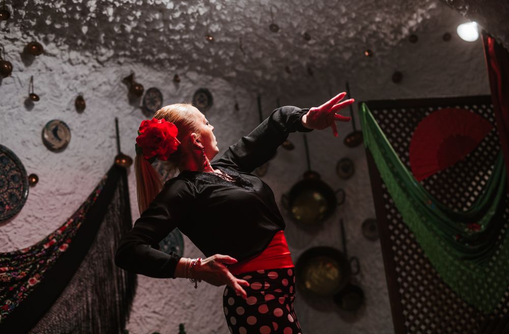 Woman dancer in flamenco costume standing in dance posture
