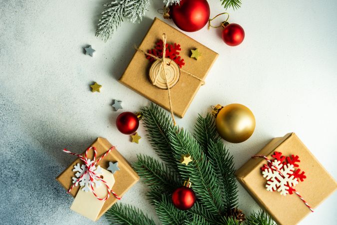 Top view of counter with fir branch, holiday baubles and three presents