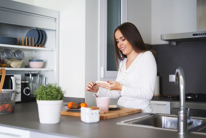 Smiling woman making sandwiches in kitchen