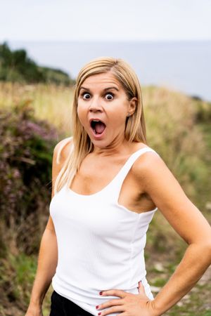 Charming woman looking at camera while walking in countryside