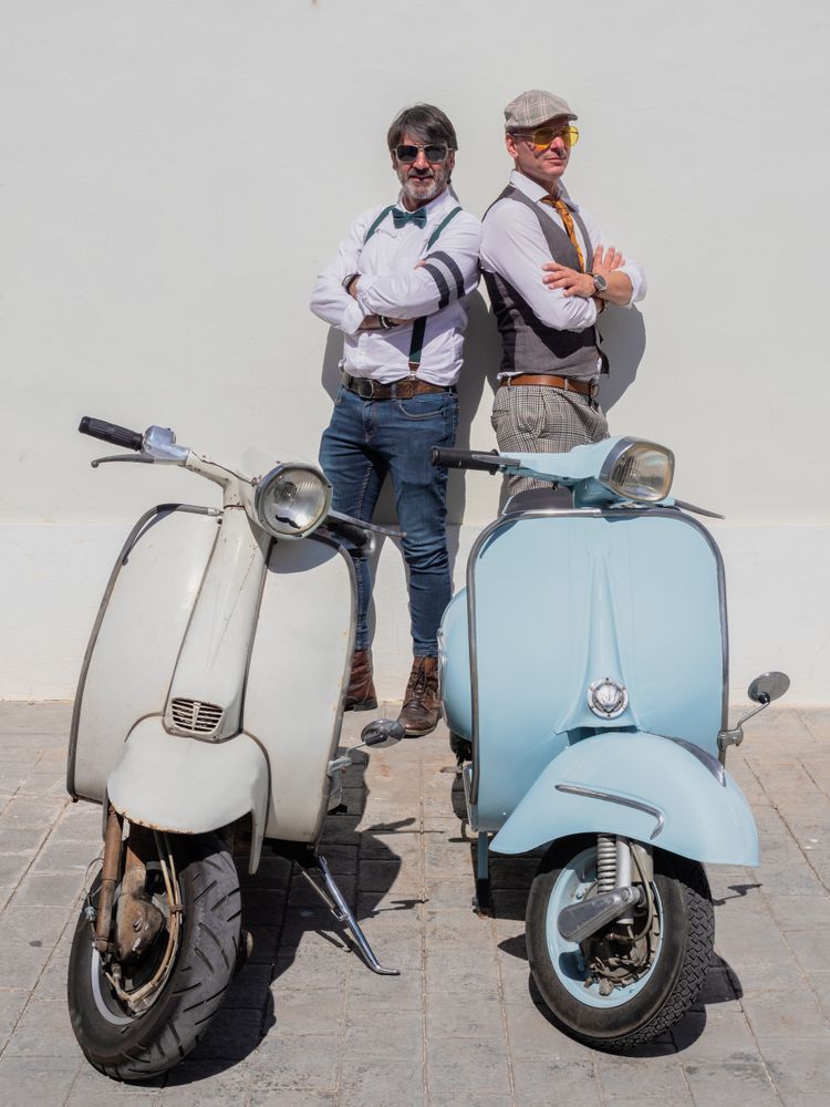 Trendy  friends posing with vintage scooters