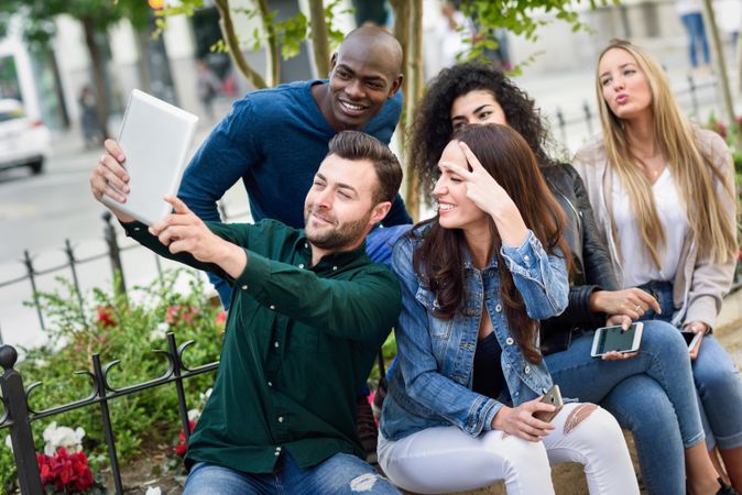 Women and men smiling taking a photo wearing casual clothes