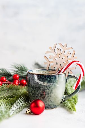 Hot drink with candy cane and decorative pine