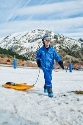 Boy with sledge in snowy mountains
