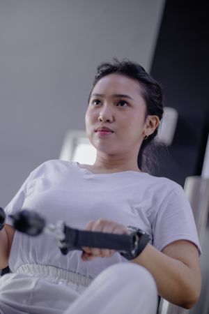 Empowered fitness journey: determined woman rowing for strength