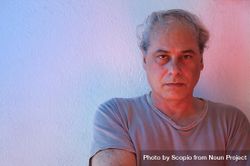 Portrait of angry middle aged man in gray shirt against light wall 437LX4