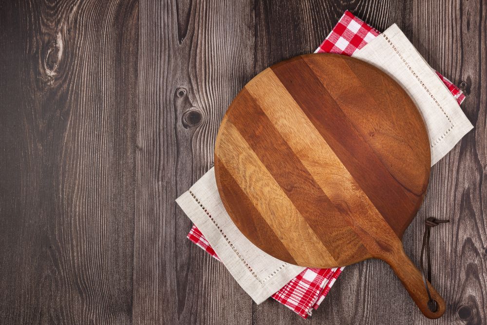 Empty pizza board on rustic wooden table. Top view image.