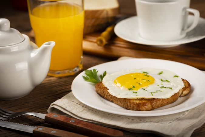 Breakfast with juice, coffee and toast with fried egg.