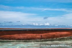 Side of red boat in tropical waters 5oyXQb
