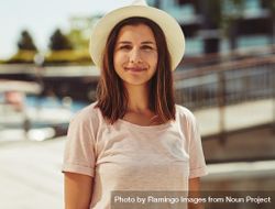 Portrait of woman standing in hat on sunny day bE1wVb