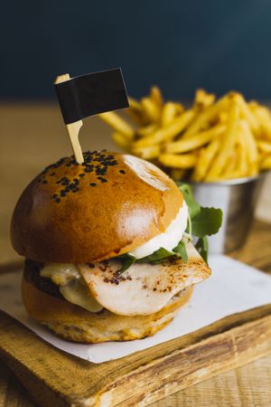 Juicy delicious burger and fried potato on table