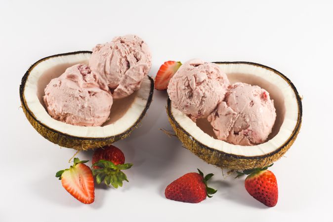 Top view of two coconut shells with delicious ice cream and strawberry fruit