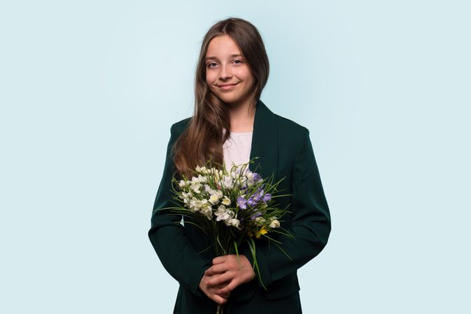 Teen girl holding bouquet of flowers, wearing blazer