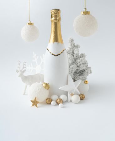 Champagne bottle and golden Christmas decoration on light background