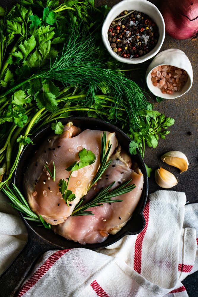 Raw chicken with rosemary sprig with seasoning