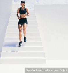 Female athlete running down stairs of building bERvA0