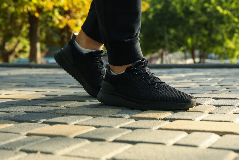 Man in sneakers and sweatpants is running in park