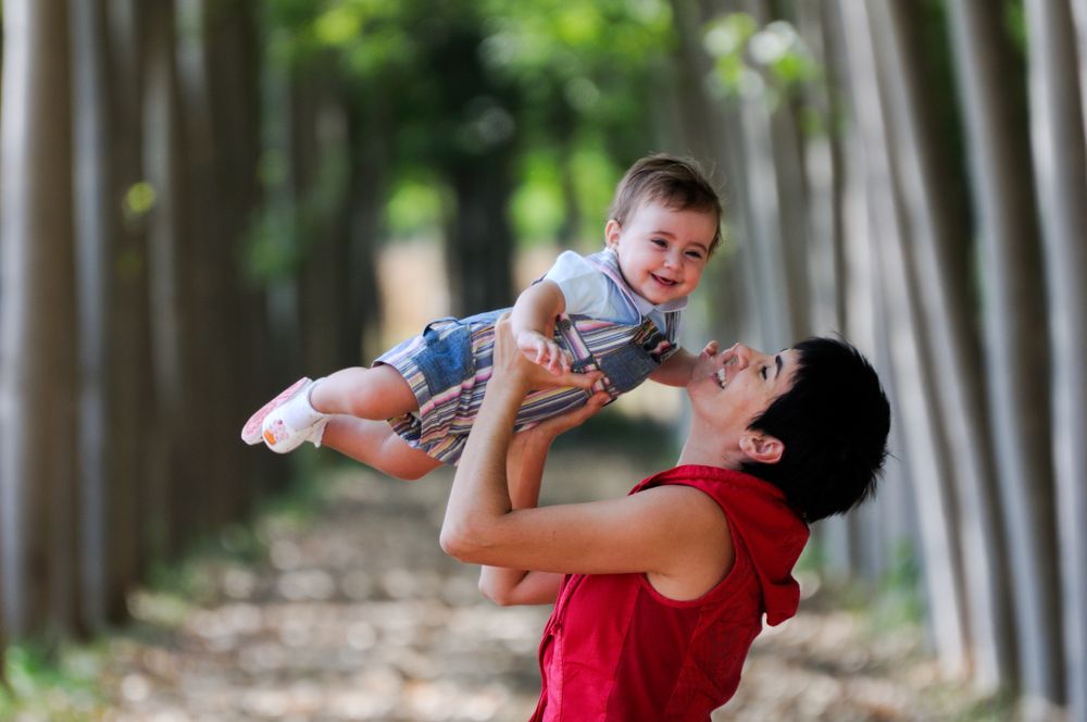 Woman with smiling little girl in forest