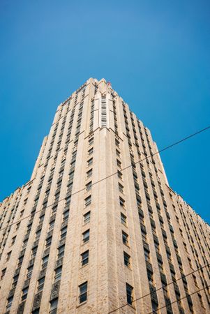 Look up at tall cream building against a blue sky